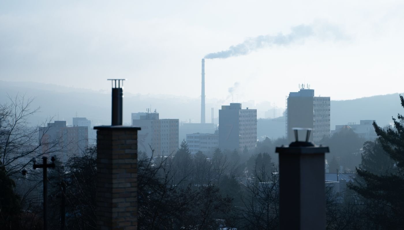 Haze and chimney smoke over a city skyline on a cold morning