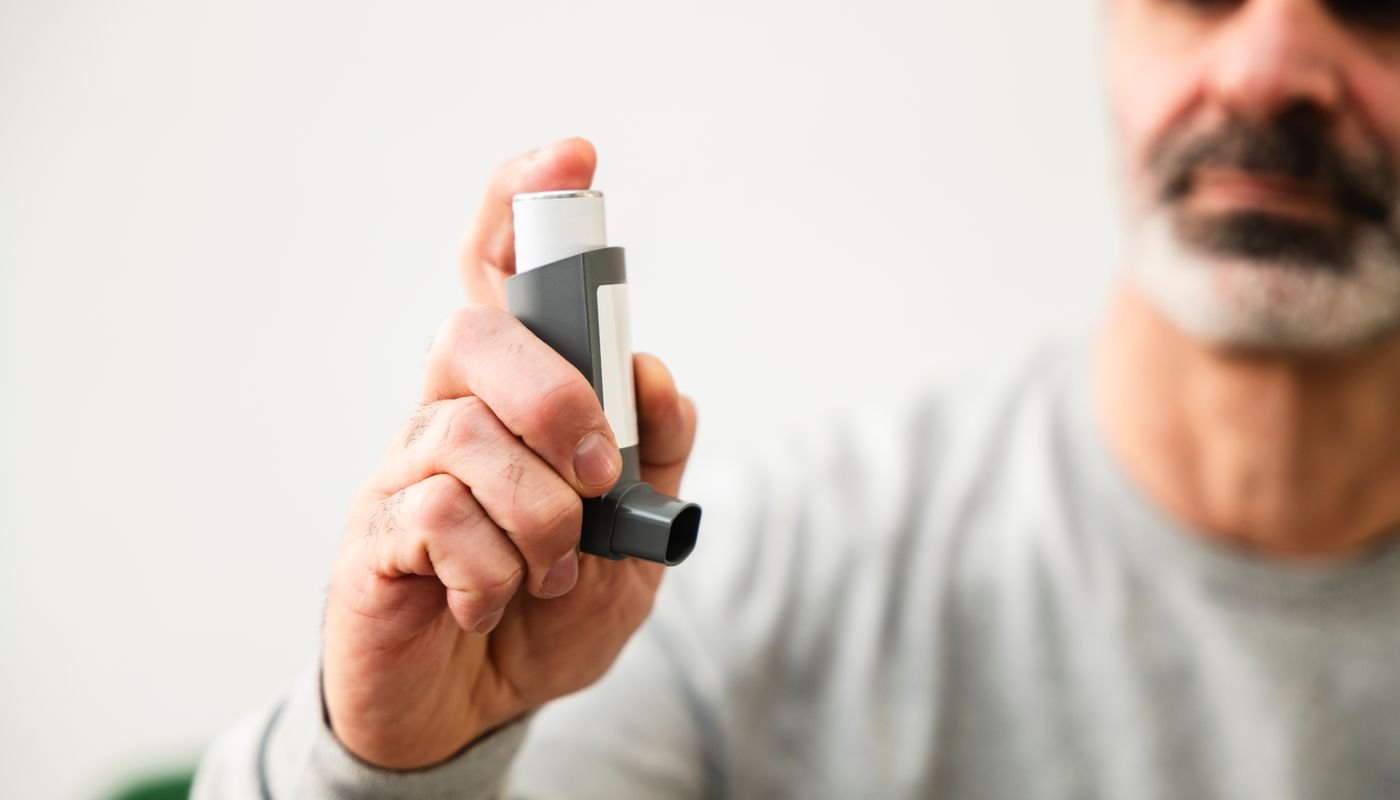 A man using a metered-dose asthma inhaler