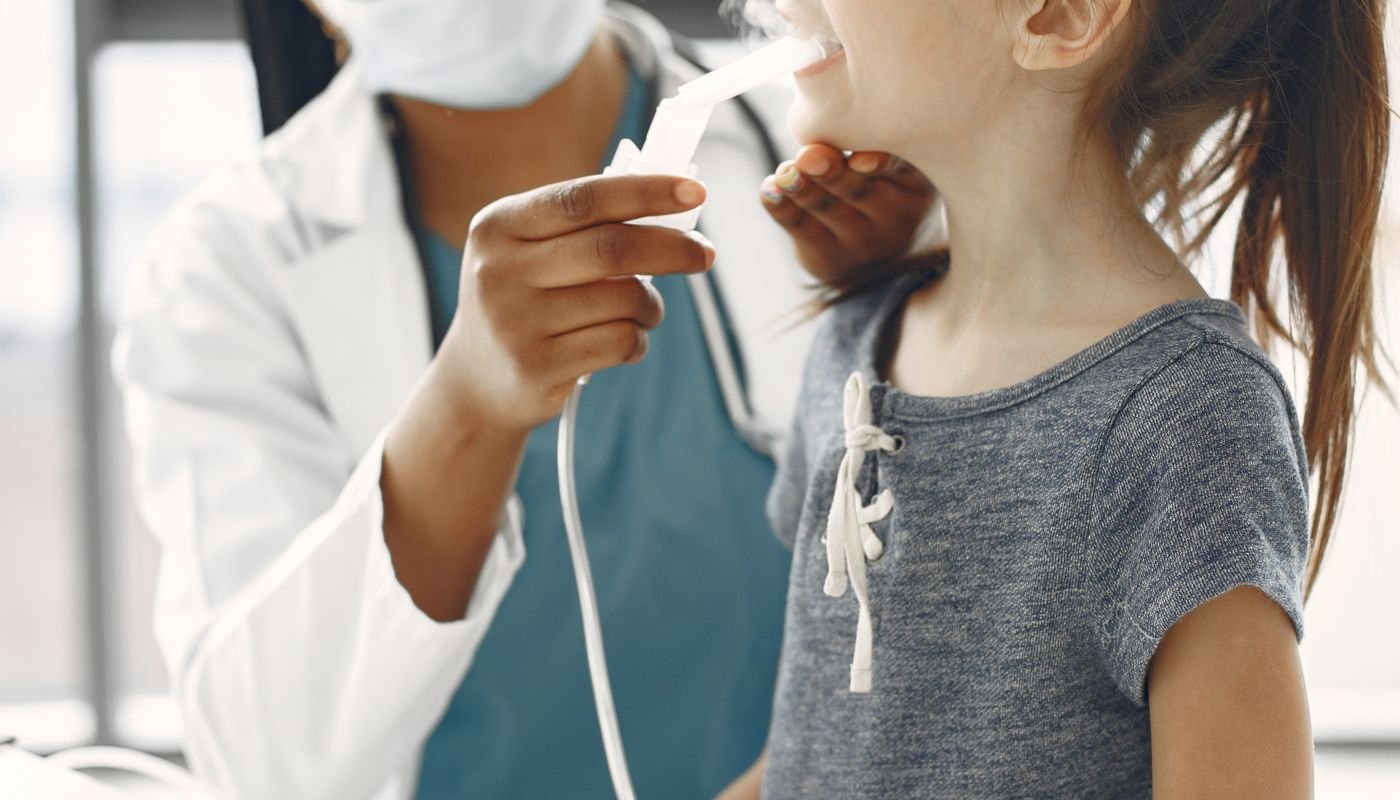 A clinician giving a child medication through a nebuliser mask