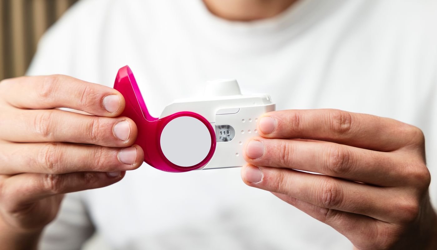 Hands holding a peak flow meter, a small hand-held breathing device